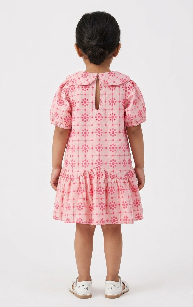 Child wearing a pink floral dress on a white background