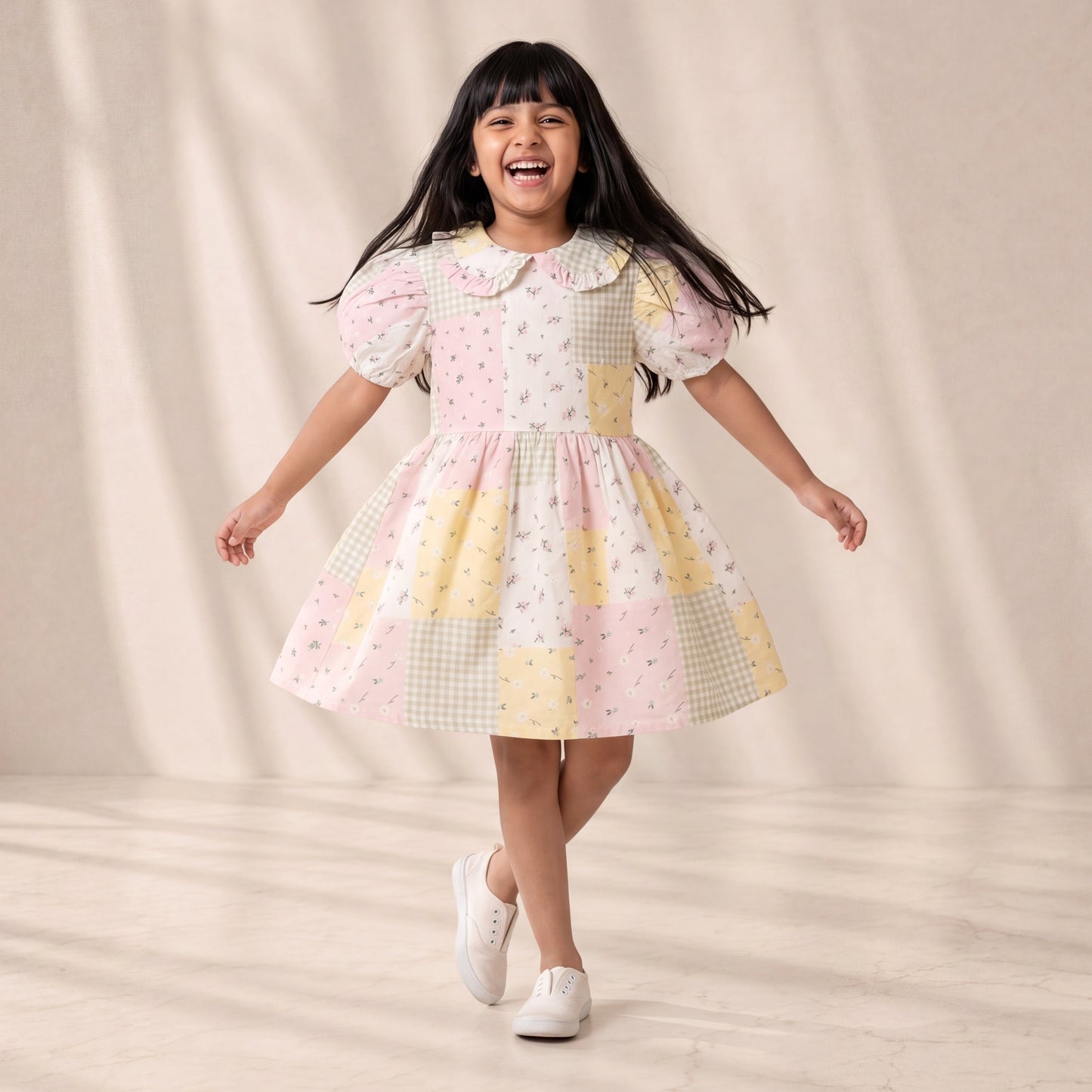 Young girl wearing a colorful dress with a patterned design on a neutral background