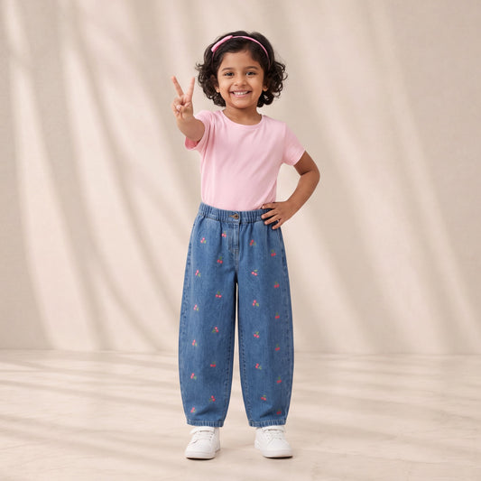 Young girl in pink shirt and blue pants with red patterns on a beige background