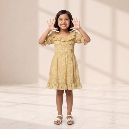 Young girl in a yellow dress standing in a softly lit room with a neutral background