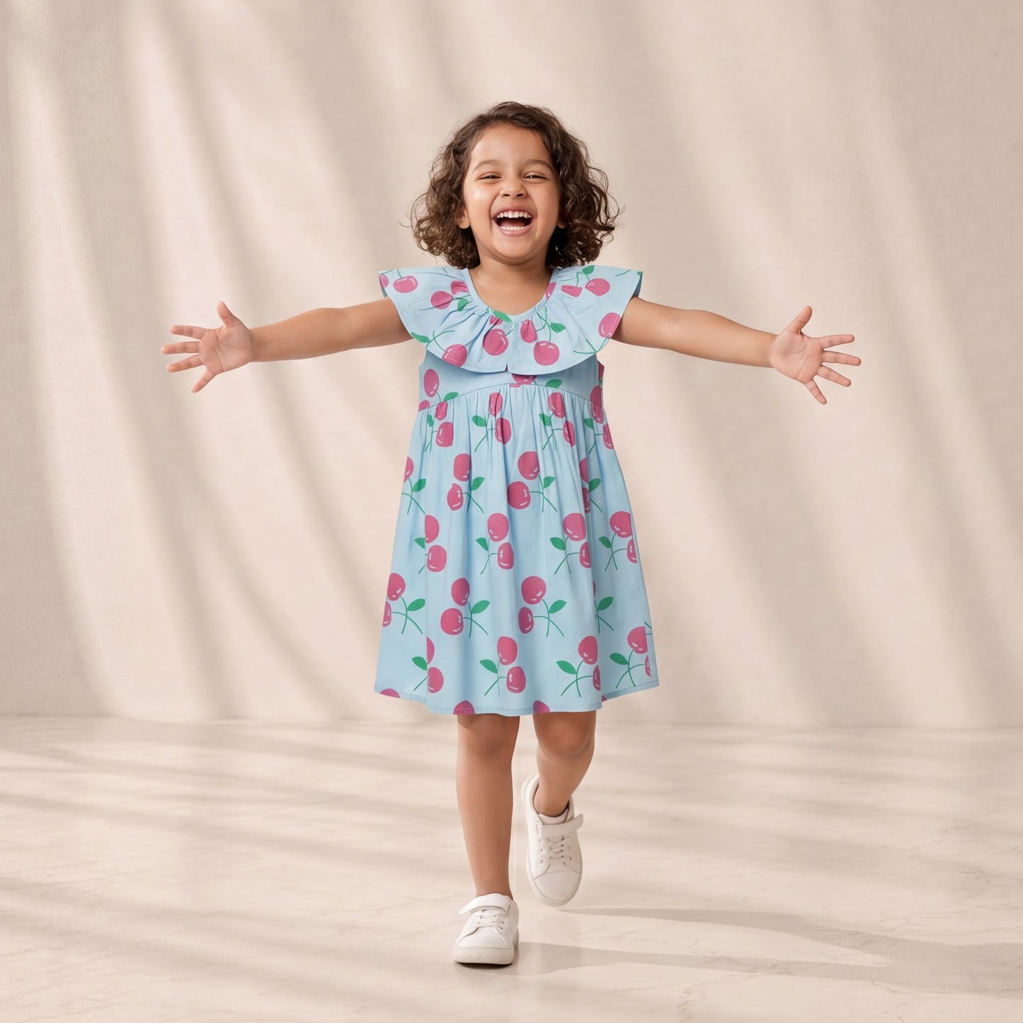Child wearing a light blue dress with pink floral pattern against a beige background