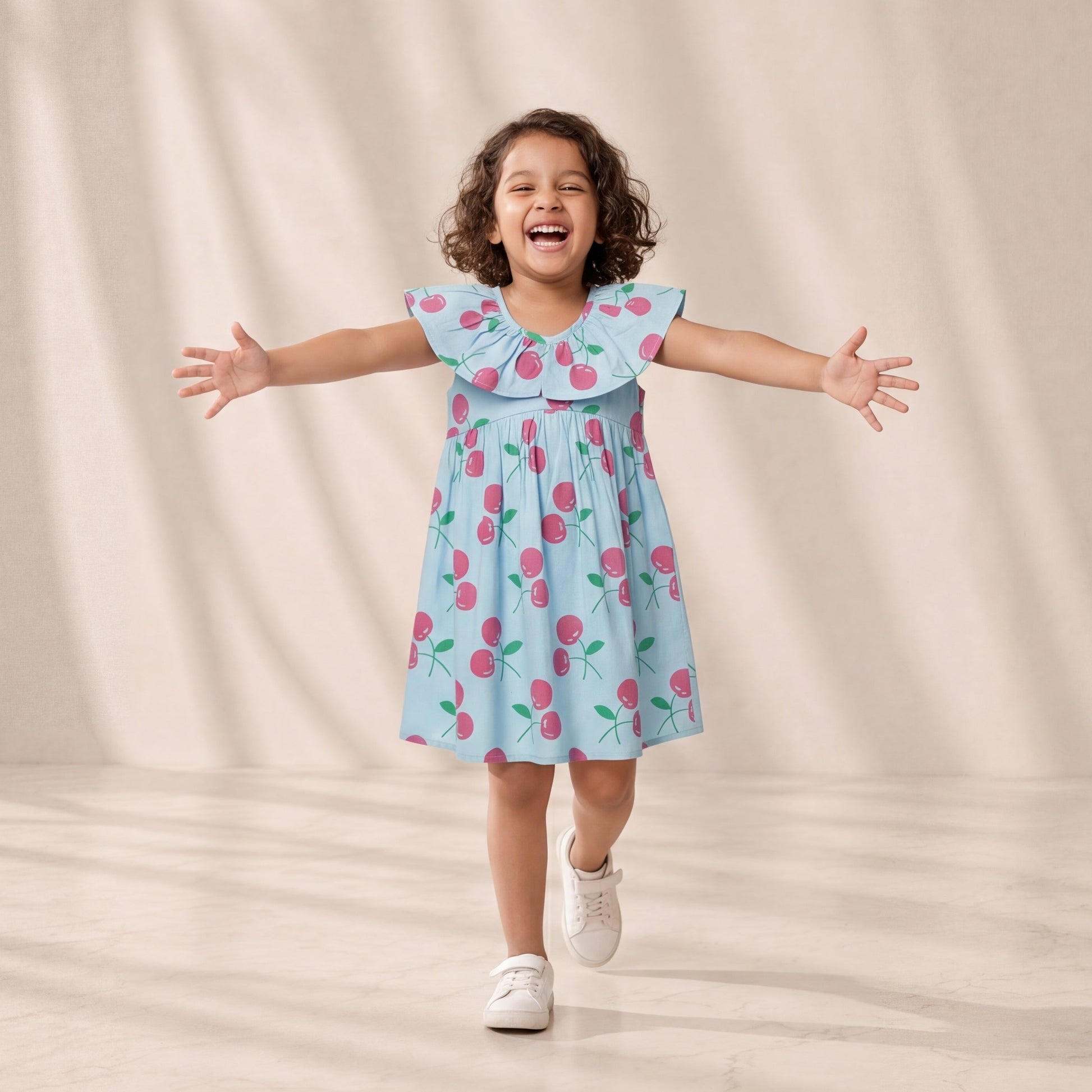 Child wearing a light blue dress with pink floral pattern against a beige background