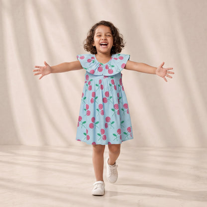 Child wearing a light blue dress with pink floral pattern against a beige background