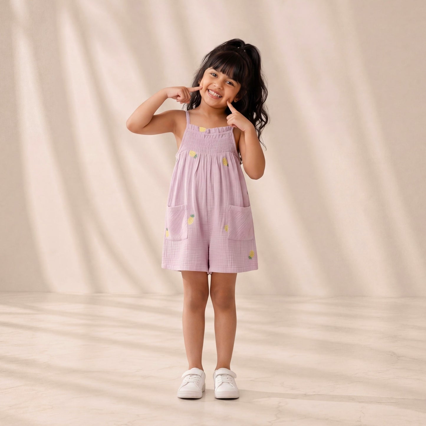 Young girl wearing a pink dress with yellow flowers on a beige background