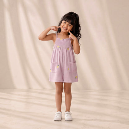Young girl wearing a pink dress with yellow flowers on a beige background