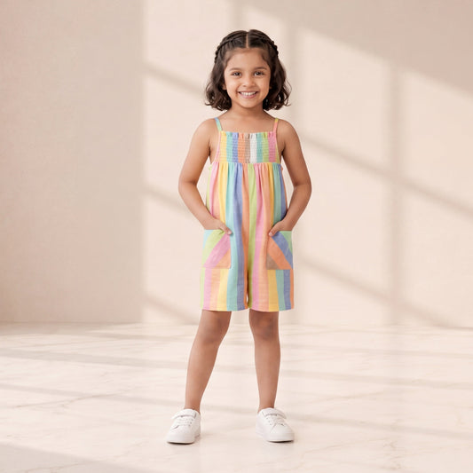 Young girl wearing a colorful dress standing in a softly lit room.
