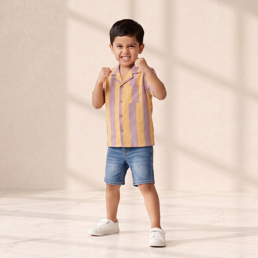 Child wearing a striped shirt and shorts on a plain background