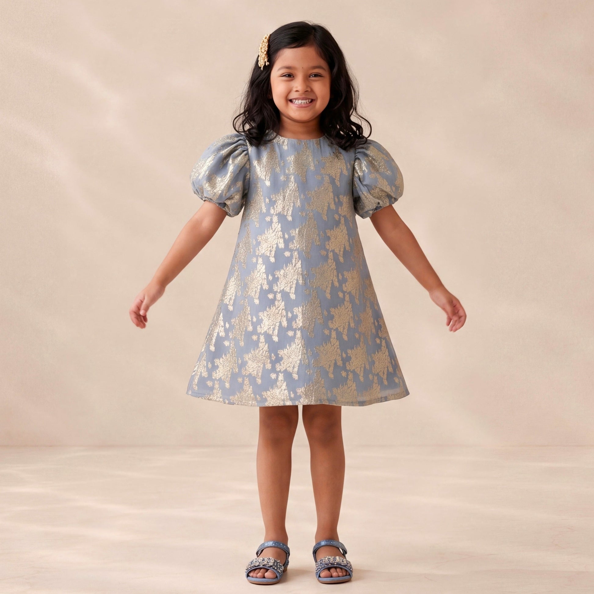 Young girl wearing a patterned dress against a plain background