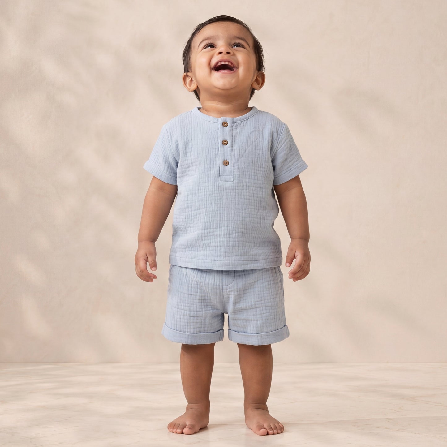 Child wearing a light blue checkered outfit on a beige background