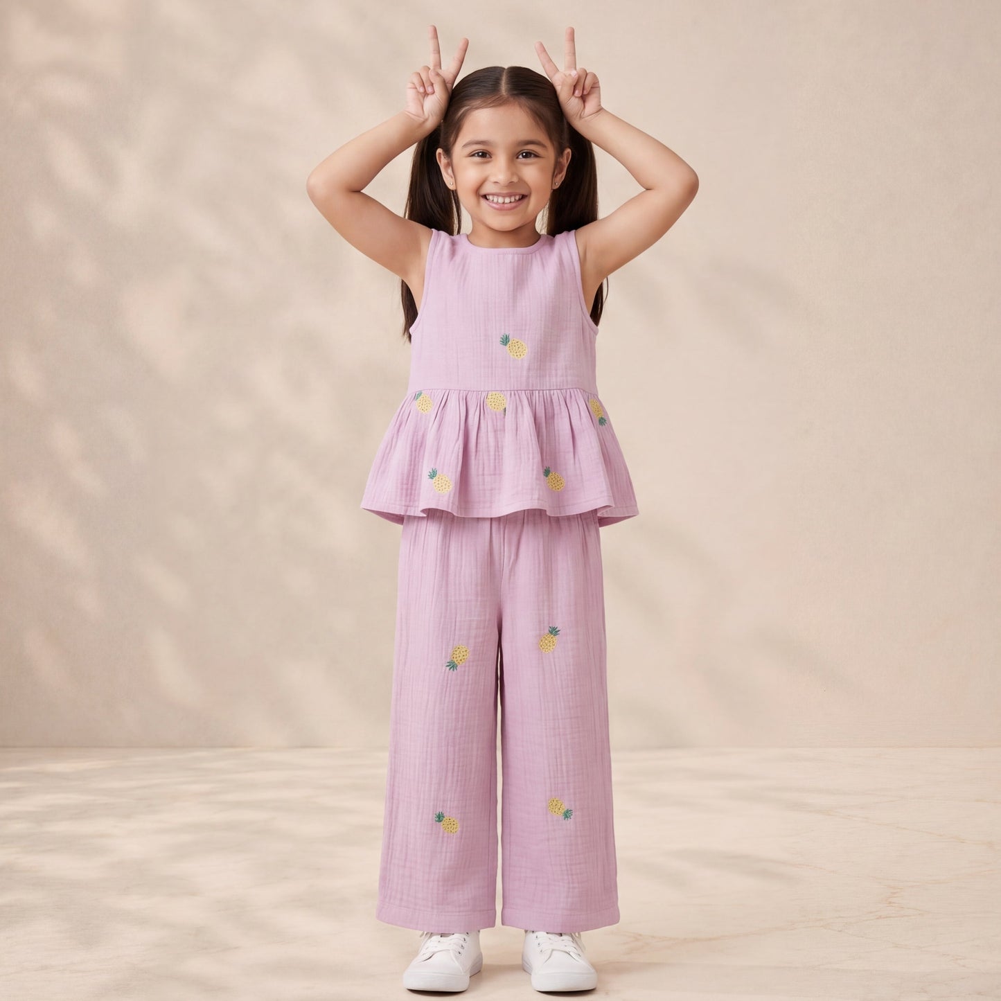 Young girl wearing a pink outfit with floral patterns on a beige background