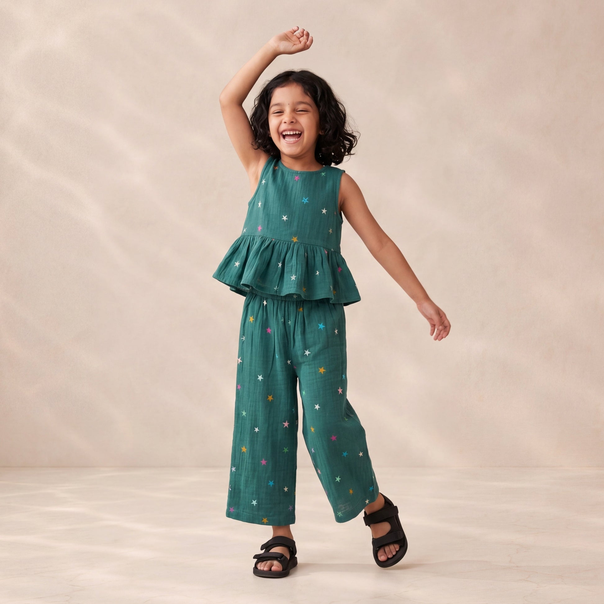 Child wearing a green outfit with colorful patterns on a beige background