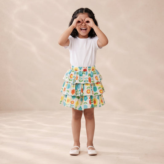 Young girl wearing a colorful skirt and white top on a beige background