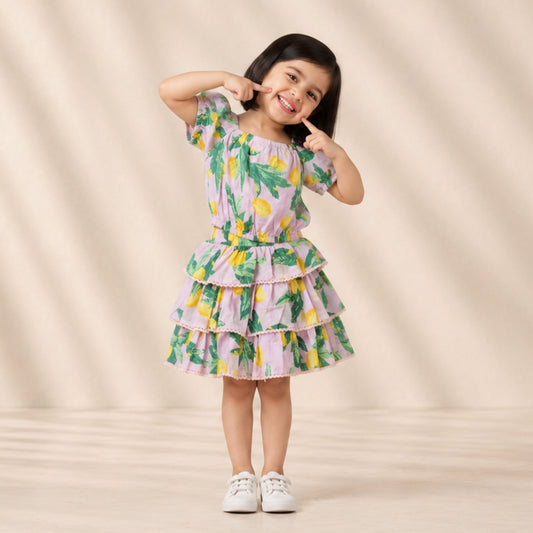 Young girl wearing a colorful dress with a lemon pattern on a beige background