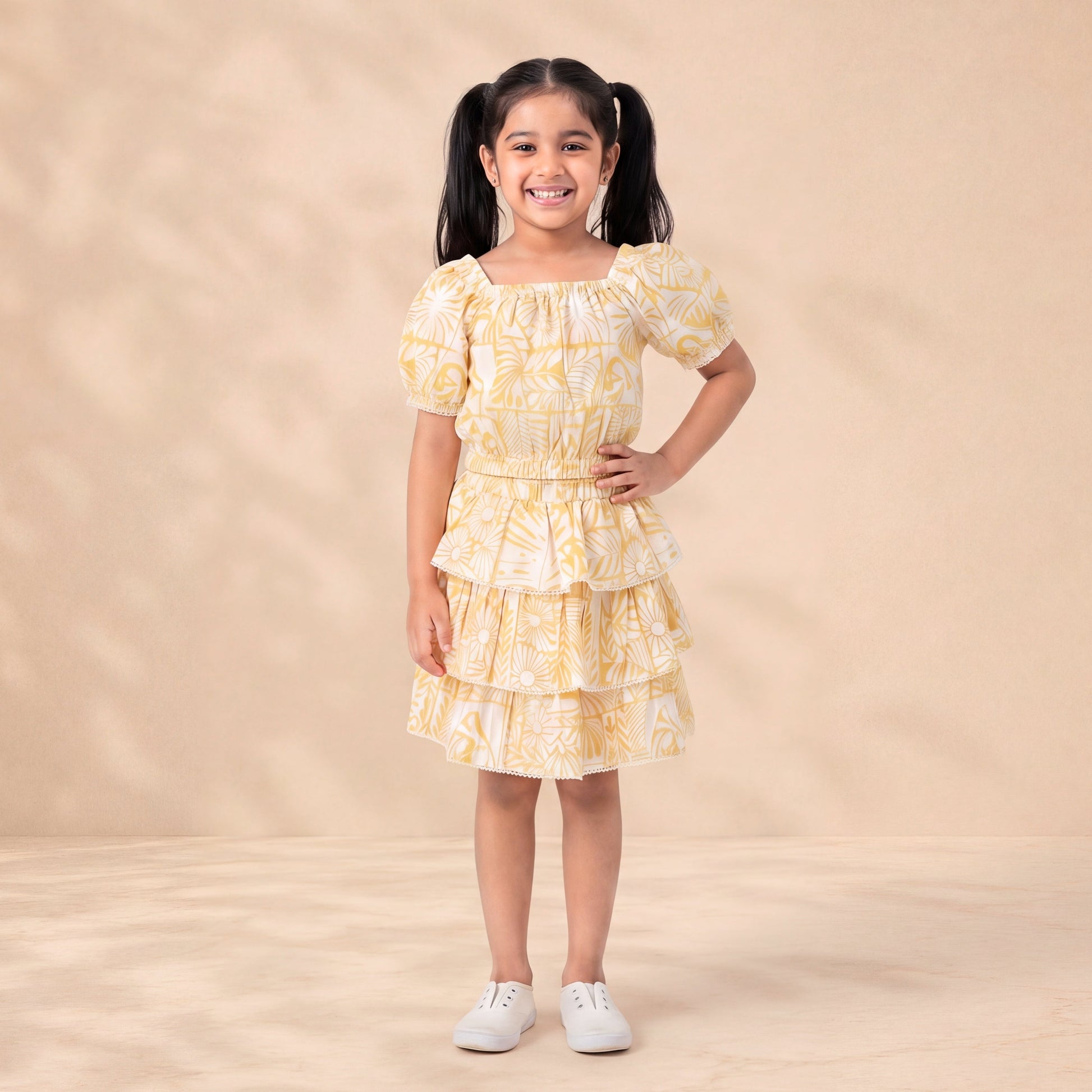 Young girl wearing a yellow and white patterned dress on a beige background